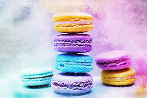 Colourful macarons in purple, blue and orange stacked on each other